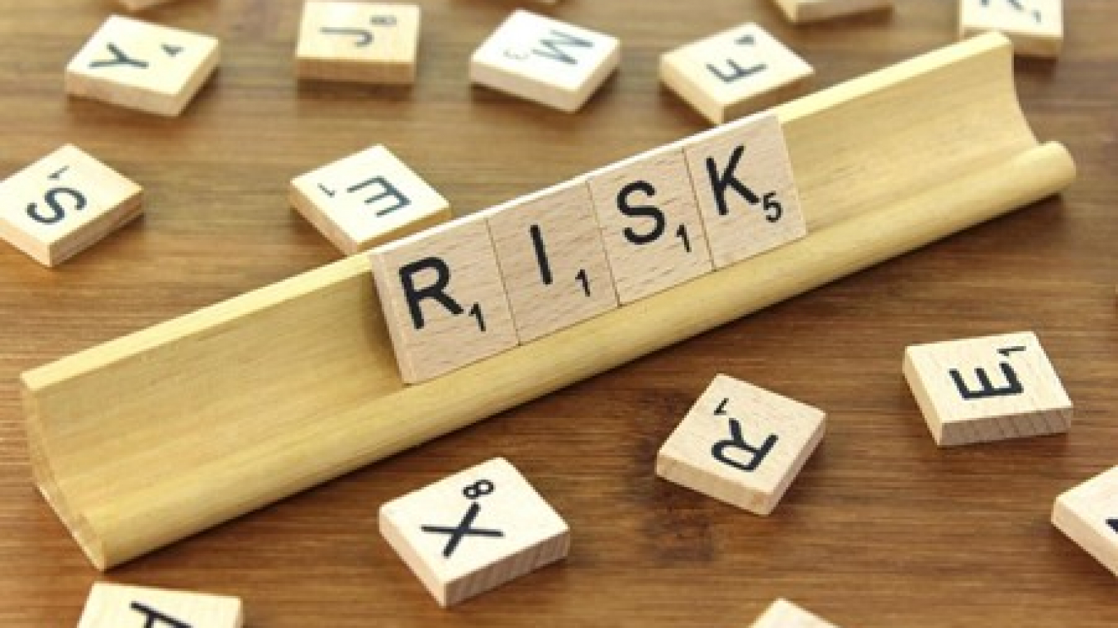 A picture showing the word risk made out of scrabble tiles